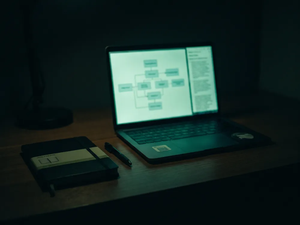 A laptop screen-sharing an architecture diagram during a dev call at night